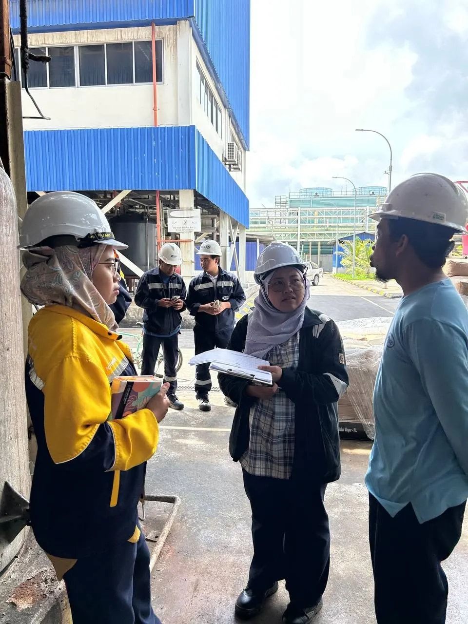 A consultant recording findings during a site visit at an industrial premises